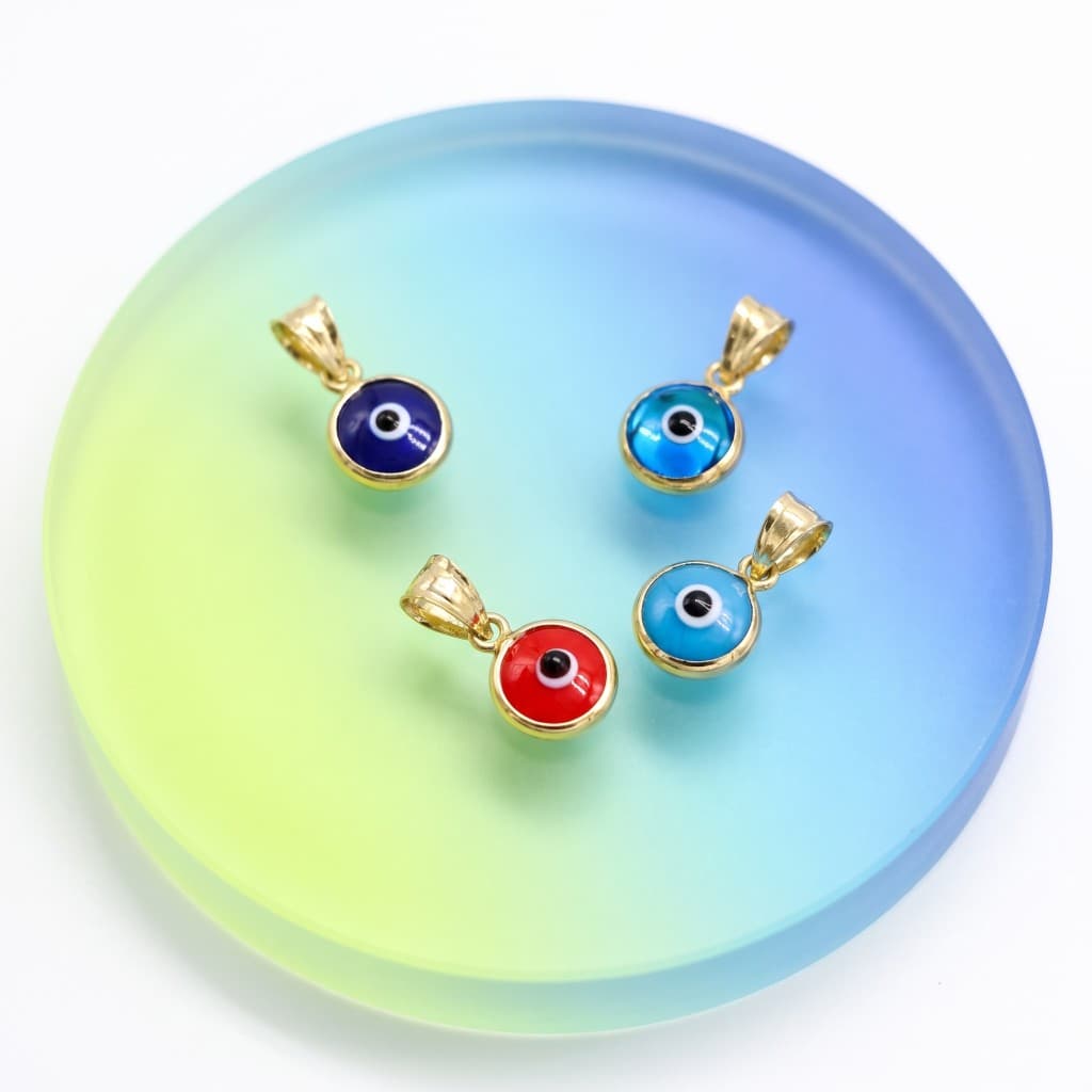 Solid 14K gold evil eye pendants in blue and red enamel on a frosted disc. Jade Gold NYC.