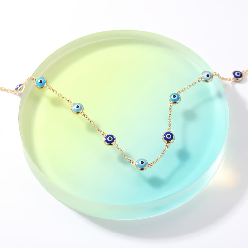 Solid 14K gold evil eye station necklace with turquoise and royal blue charms on a frosted disc.