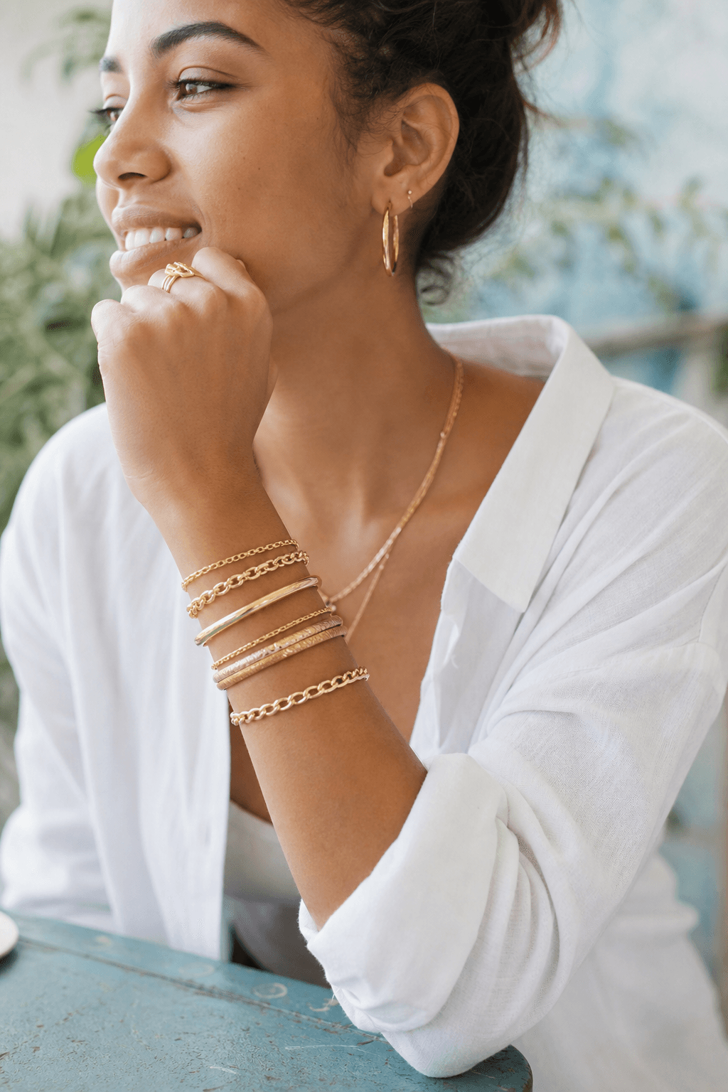 A stack of solid gold bracelets worn on a wrist.