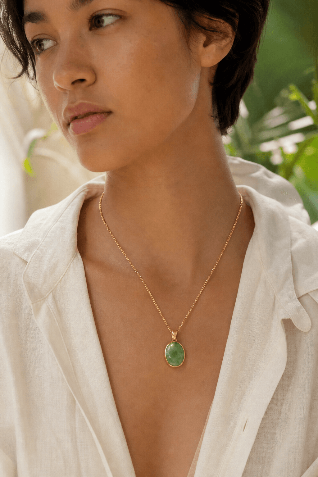 Person wearing a solid 14K gold pendant set with natural Type A jade.